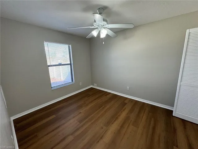 Guest bedroom 1 with ceiling fan and dark hardwood / wood-style floors