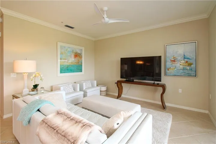 Living room with baseboards, visible vents, a ceiling fan, and light tile patterned floors