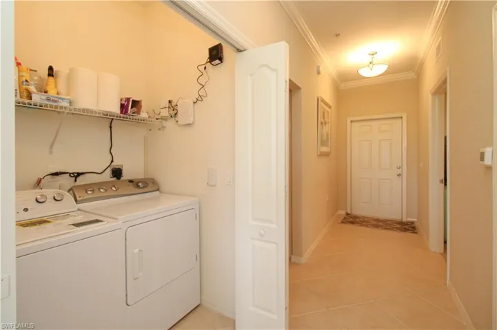 Laundry area featuring visible vents, ornamental molding, laundry area, separate washer and dryer, and light tile patterned floors
