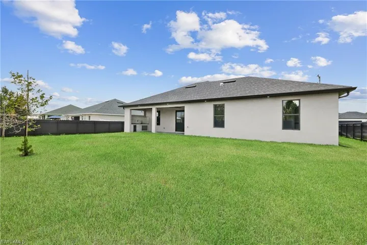 Rear view of house featuring a yard