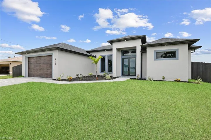 Prairie-style home with a garage and a front yard