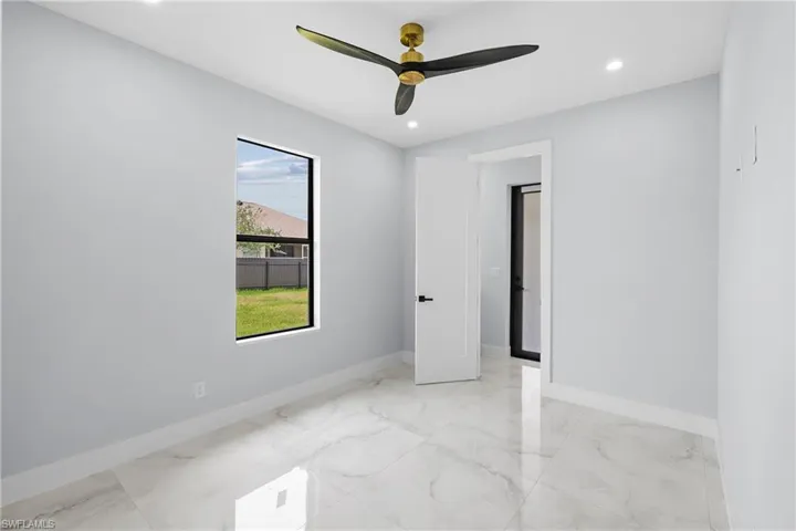 Tiled spare room with ceiling fan