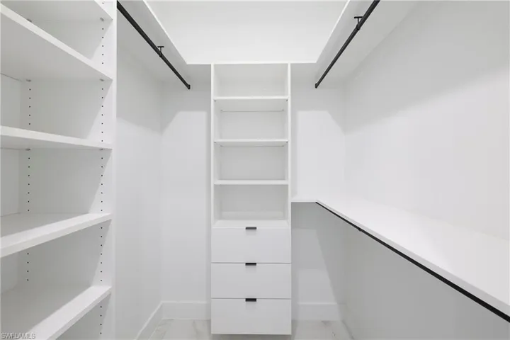 Spacious closet with light tile patterned floors