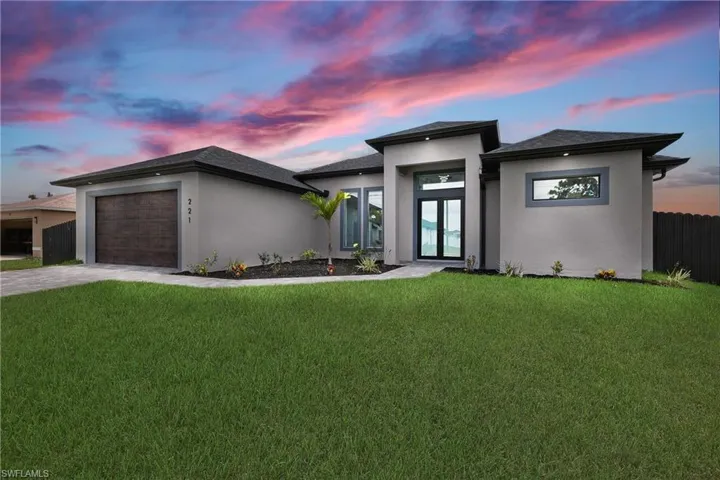 Prairie-style home featuring a garage and a lawn