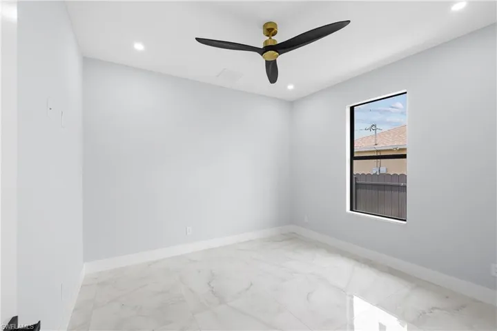 Unfurnished room featuring light tile patterned flooring and ceiling fan