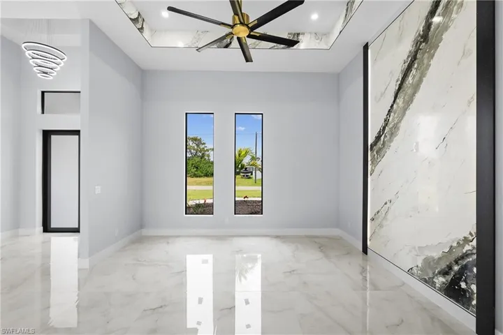 Unfurnished room with light tile patterned floors and ceiling fan