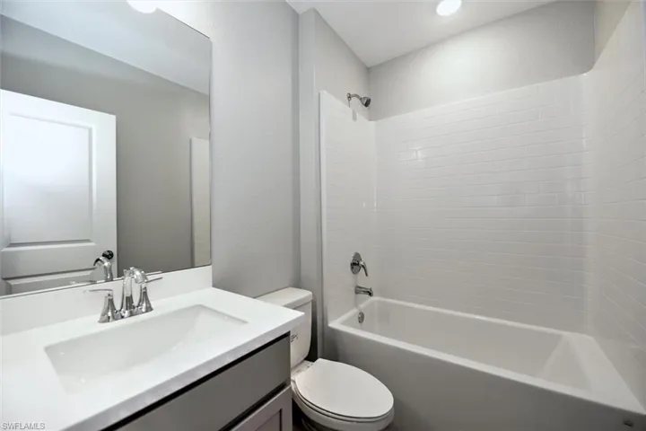Full bathroom featuring vanity, toilet, and tub / shower combination