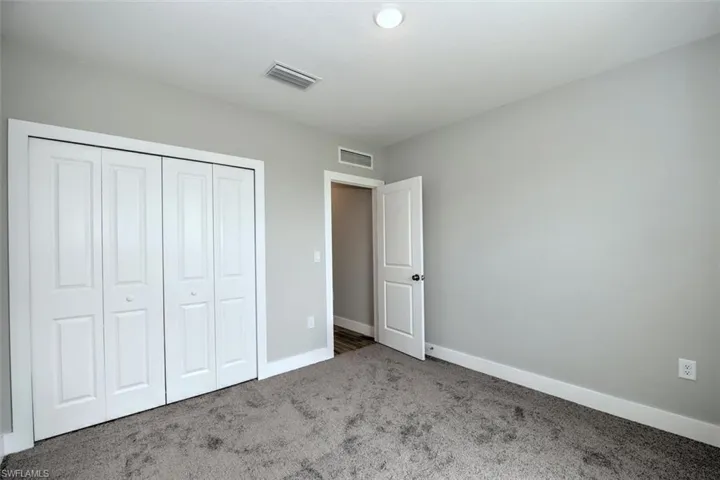 Unfurnished bedroom with carpet flooring and a closet