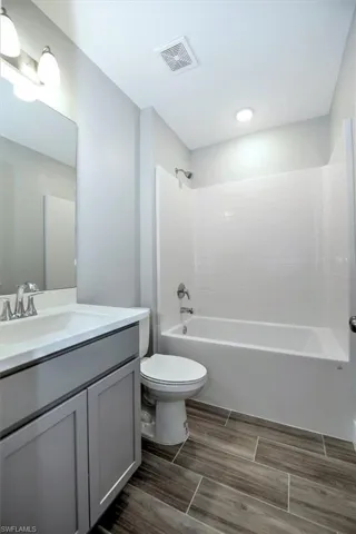 Full bathroom featuring vanity, toilet, and  shower combination
