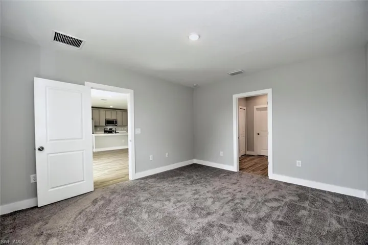 Unfurnished bedroom featuring dark carpet