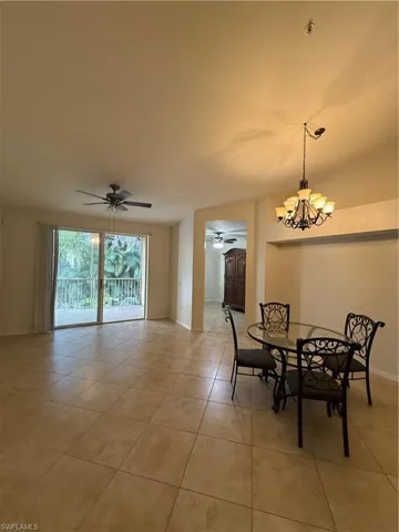 Dining area with a chandelier, light tile patterned flooring, and a ceiling fan