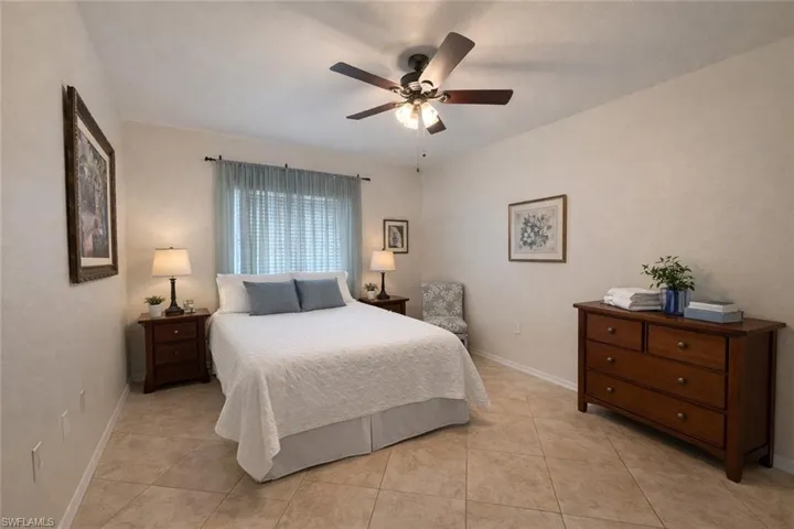 Bedroom with ceiling fan and light tile patterned floors