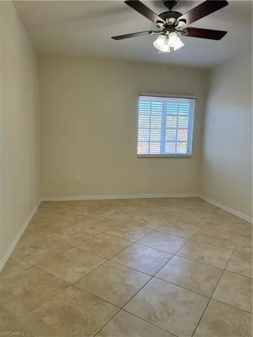 Spare room featuring a ceiling fan and light tile patterned floors