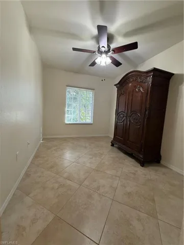 Unfurnished bedroom with ceiling fan and light tile patterned floors