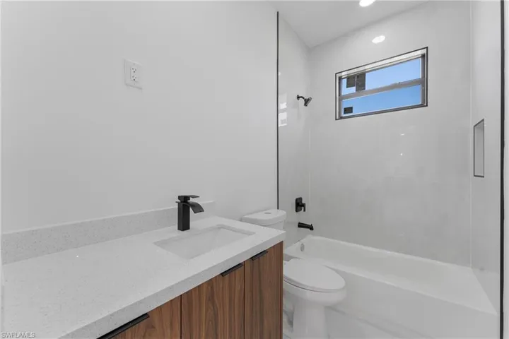 Full bathroom featuring vanity, toilet, and tiled shower / bath