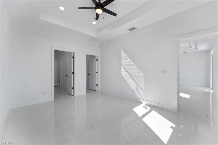 Spare room with ceiling fan and a tray ceiling