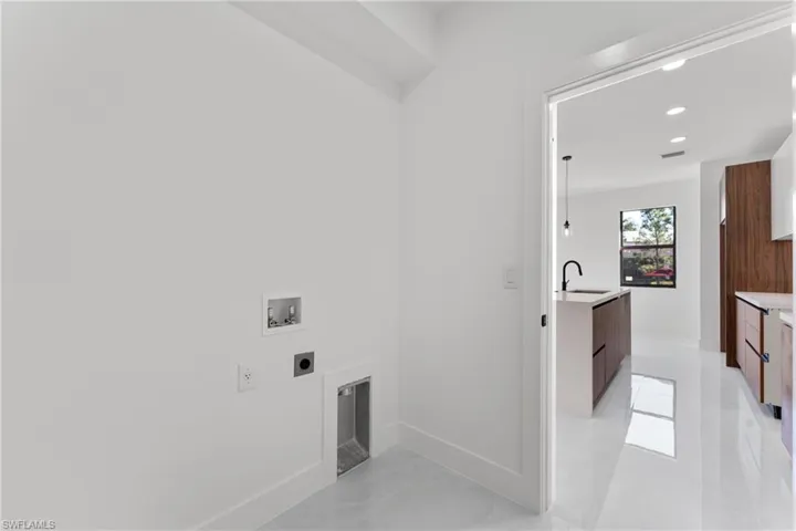 Laundry room featuring hookup for a washing machine, sink, hookup for an electric dryer, and a fireplace