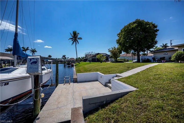 concrete dock with boat lift water and electric