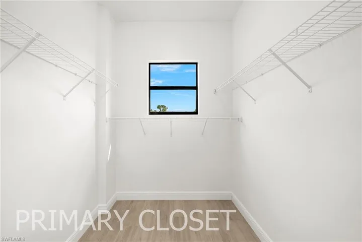 Spacious closet featuring hardwood / wood-style flooring