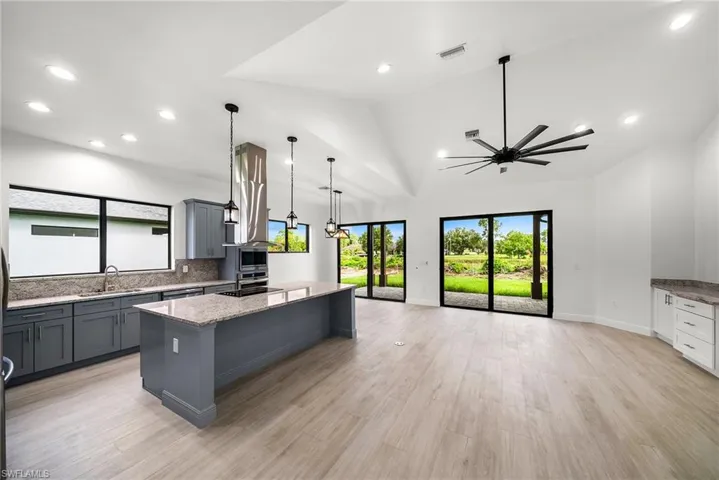Kitchen featuring a center island, ceiling fan, light hardwood / wood-style flooring, and decorative light fixtures