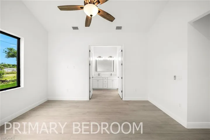 Spare room with plenty of natural light, ceiling fan, and light hardwood / wood-style floors
