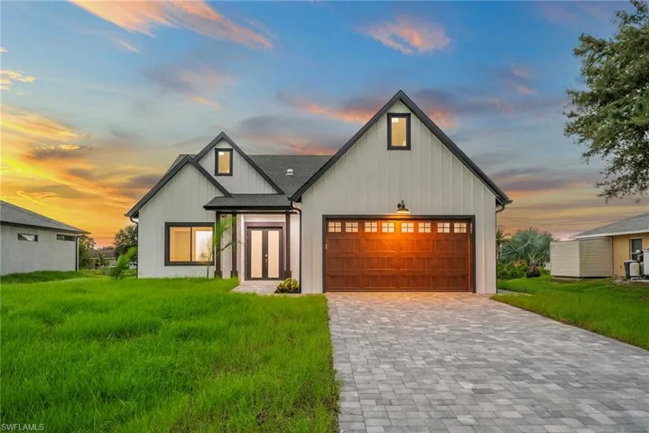 Modern farmhouse style home with a lawn and a garage