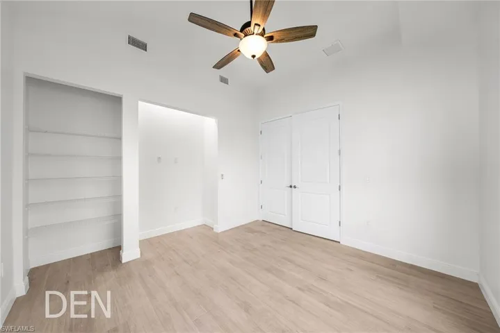 Unfurnished bedroom with ceiling fan and light wood-type flooring