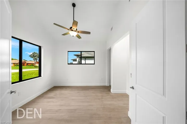 Spare room with lofted ceiling, ceiling fan, and light hardwood / wood-style floors
