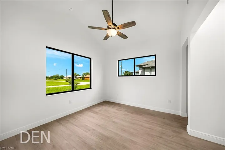 Empty room featuring a healthy amount of sunlight, ceiling fan, and light wood-type flooring