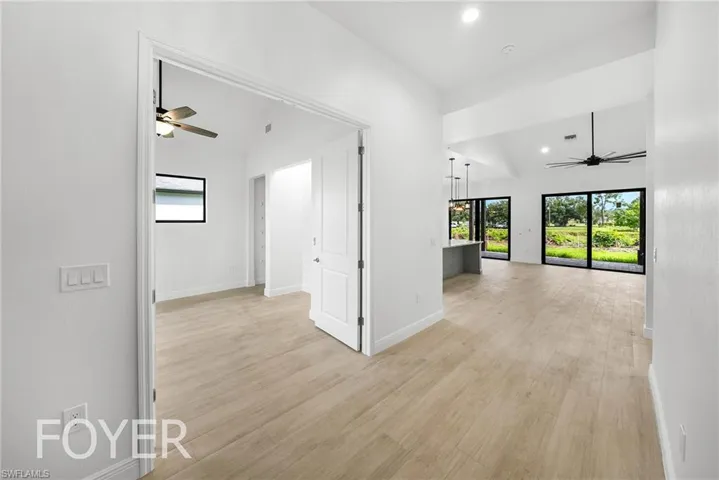 Corridor featuring lofted ceiling and light hardwood / wood-style floors