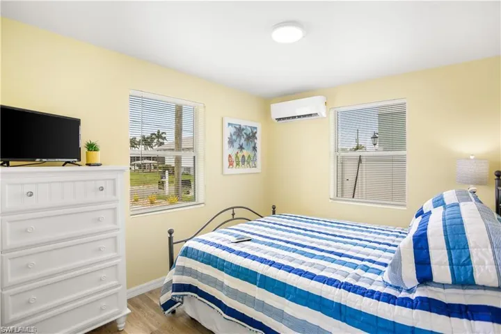 Bedroom with light wood-type flooring and a wall unit AC