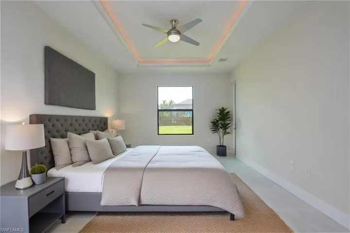 Bedroom featuring ceiling fan and a raised ceiling