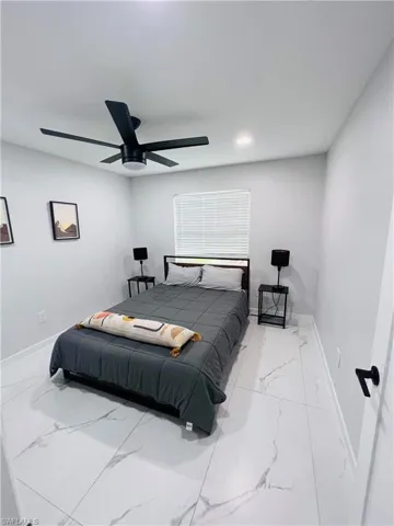 White tile flooring, recessed lighting, ceiling fan, window with blinds, and a white door with matte black hardware