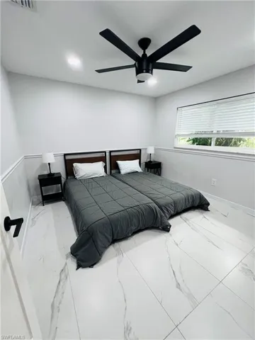 White tile flooring, black ceiling fan with integrated lighting, recessed ceiling lights, horizontal window blinds, and white wall paneling
