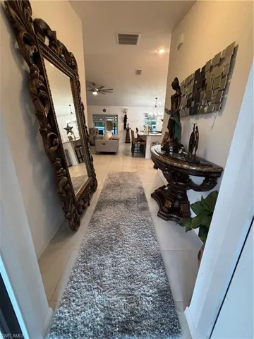 Hall with tile patterned floors and visible vents