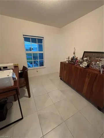 Office space featuring light tile patterned flooring and baseboards