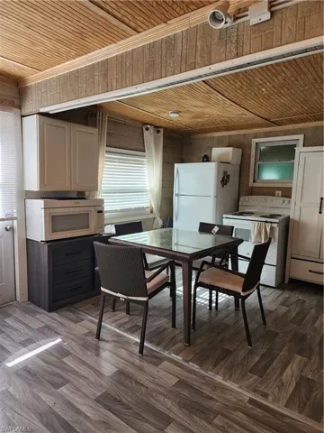 Dining space featuring wood walls, wood ceiling, and hardwood / wood-style floors, new kitchen aplliances