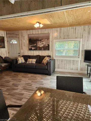 Living room with wood ceiling, wood walls, and hardwood / wood-style flooring