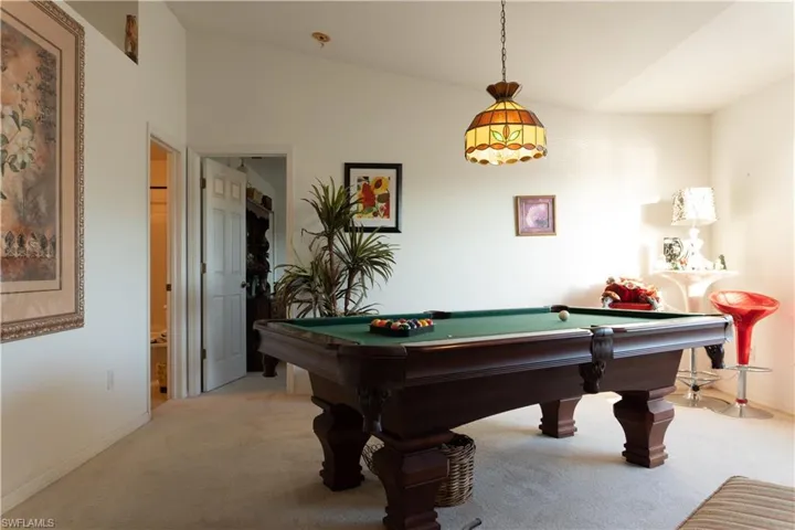 Game room with light carpet, billiards, and lofted ceiling