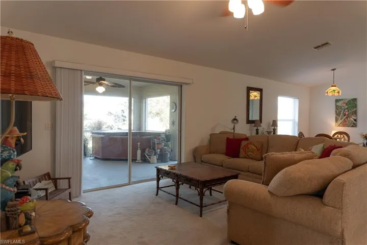 Carpeted living room featuring lofted ceiling and ceiling fan