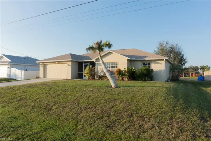 Single story home featuring a garage and a front yard