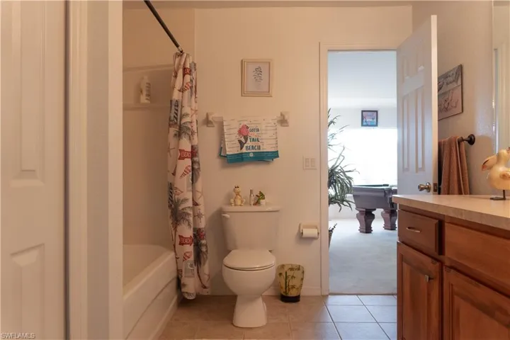 Full bathroom featuring vanity, tile patterned floors, shower / bath combination with curtain, and toilet