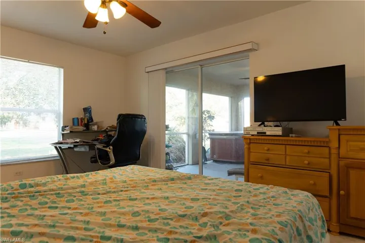 Bedroom with ceiling fan, access to exterior, and multiple windows