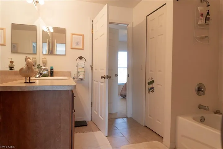 Bathroom featuring tiled shower / bath combo, vanity, and tile patterned floors