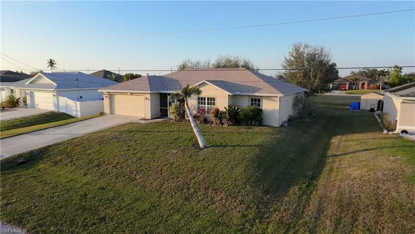 Single story home with a garage and a front yard