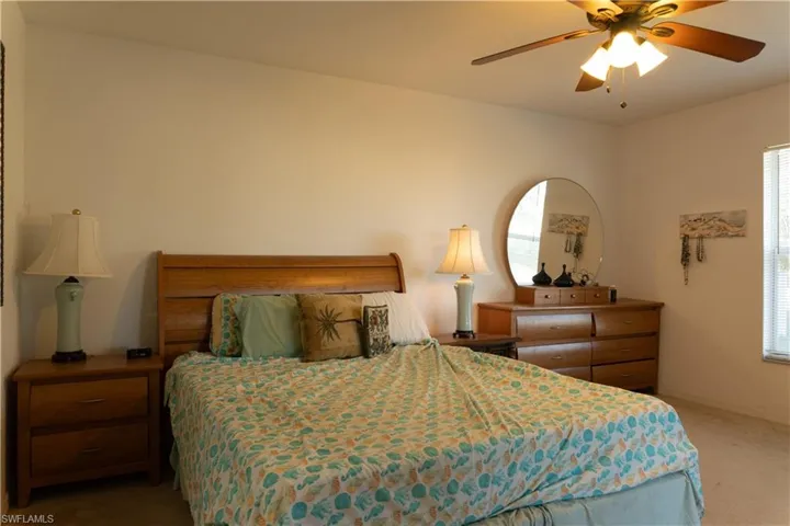 Carpeted bedroom featuring ceiling fan