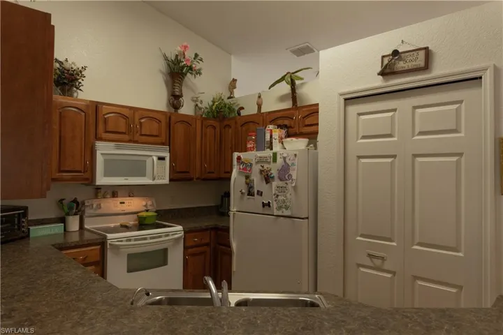 Kitchen with white appliances and sink