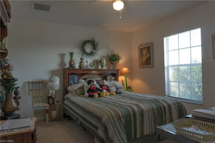 Carpeted bedroom featuring radiator and ceiling fan