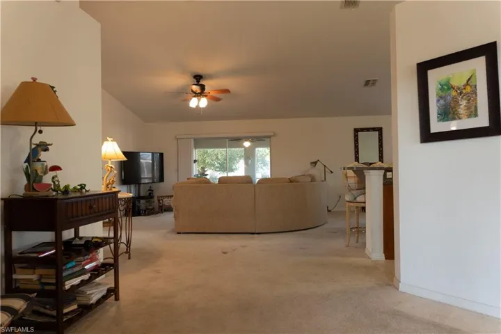 Carpeted living room with ceiling fan