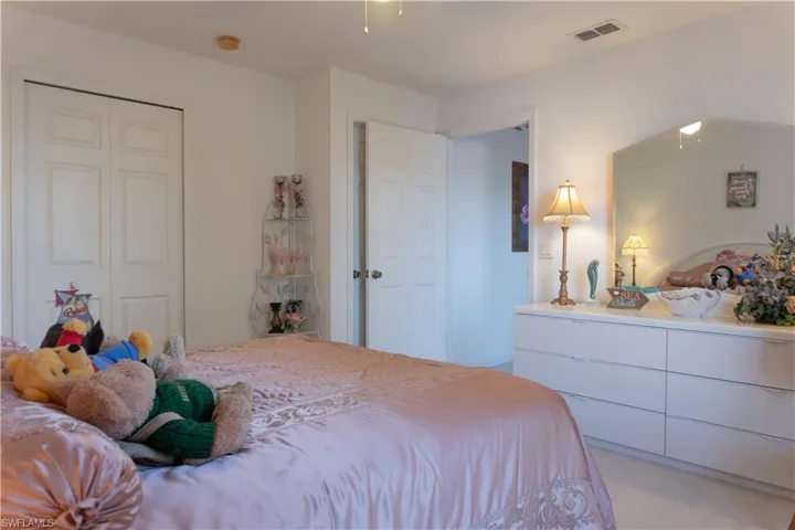 Carpeted bedroom with a closet